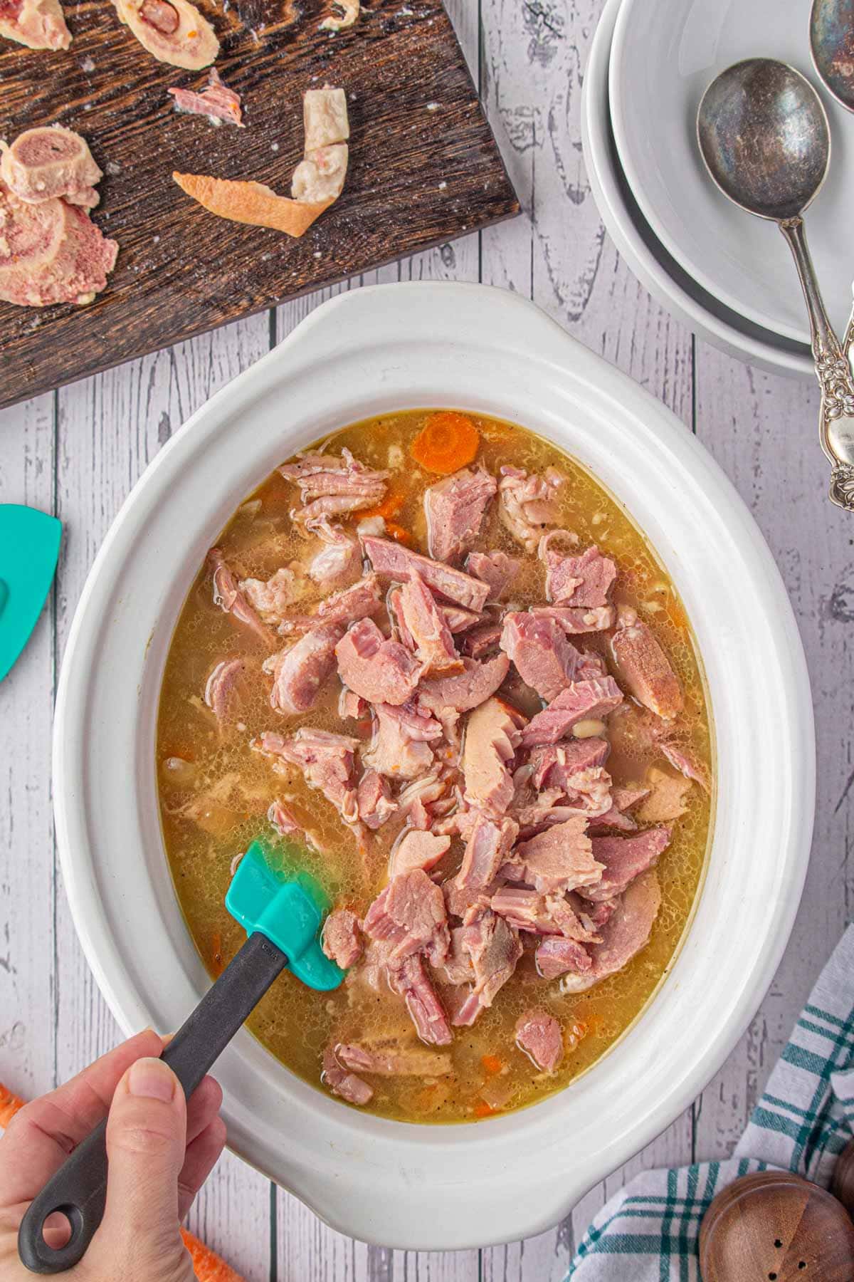 Stirring the ham and bean soup in the slow cooker.