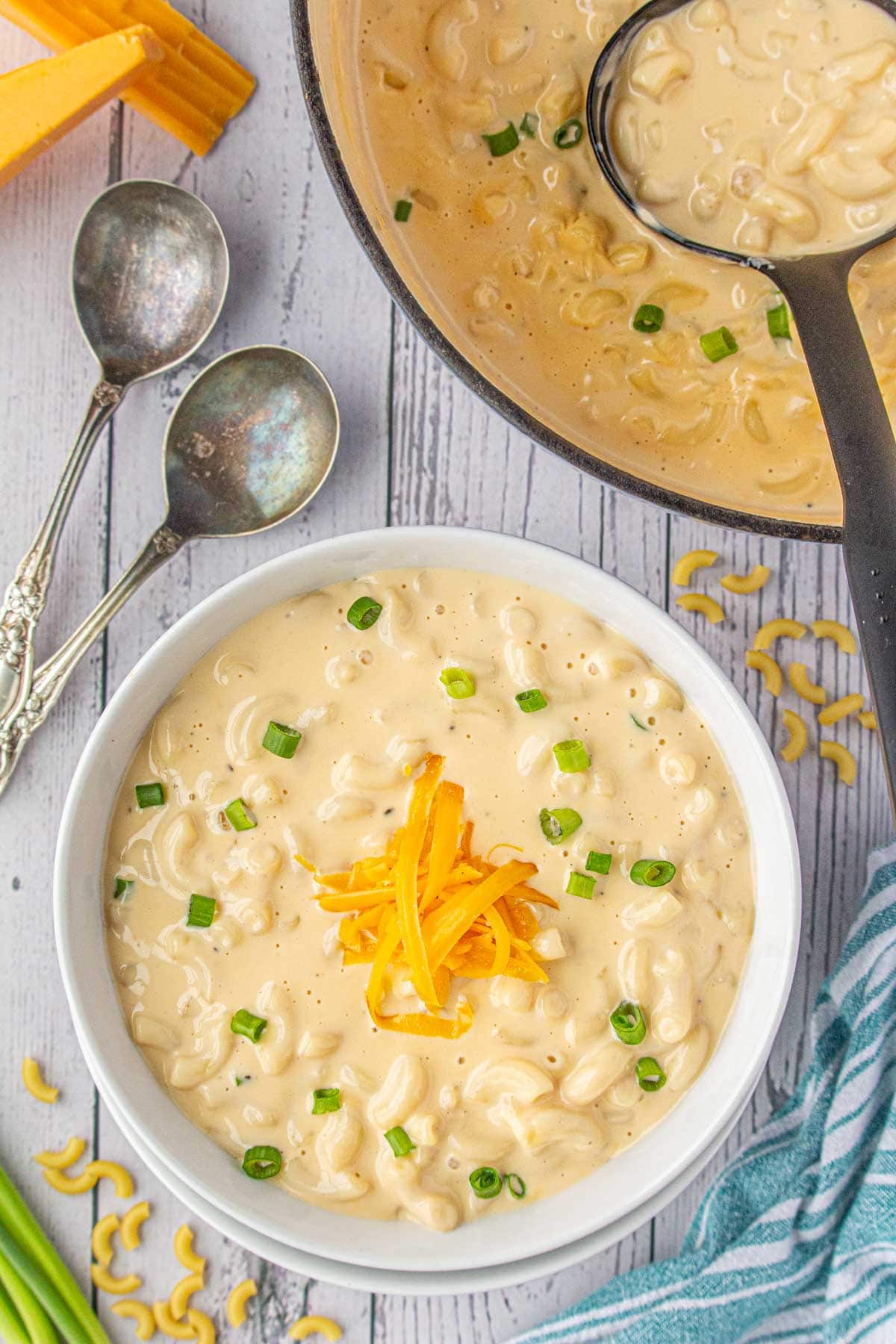 An overhead view of creamy macaroni and cheese soup in a dinner bowl.