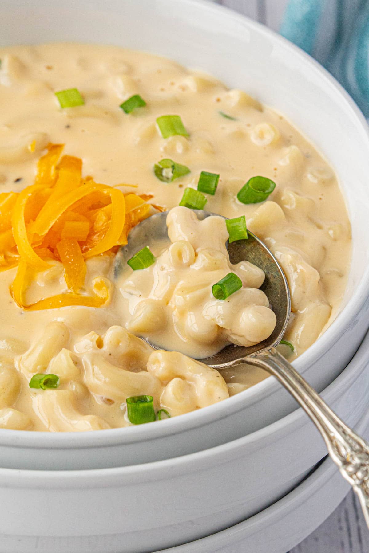 An angled view of a bowl of creamy macaroni and cheese soup.