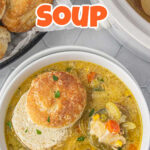 Overhead view of a bowl of chicken pot pie soup with a biscuit on top - title text overlay for Pinterest.