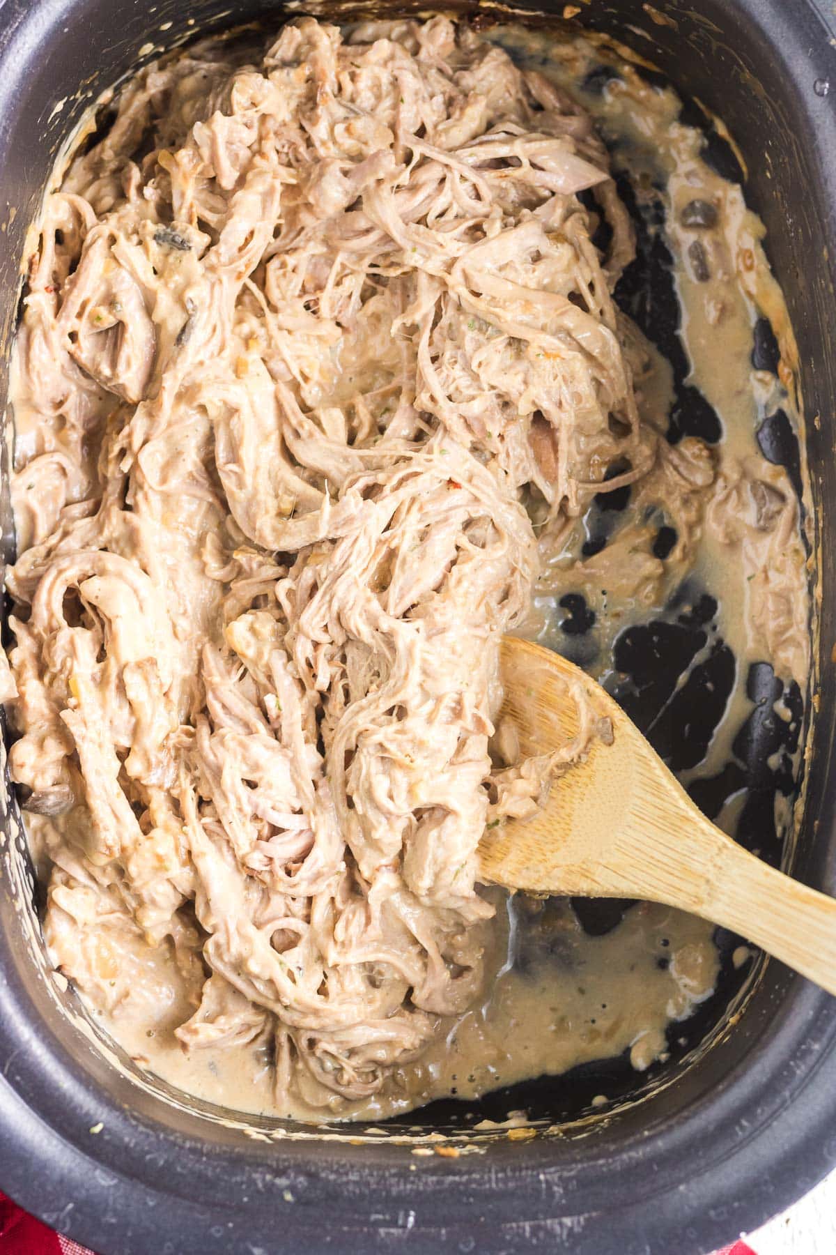 Scooping out the shredded creamy slow cooked pork tenderloin.