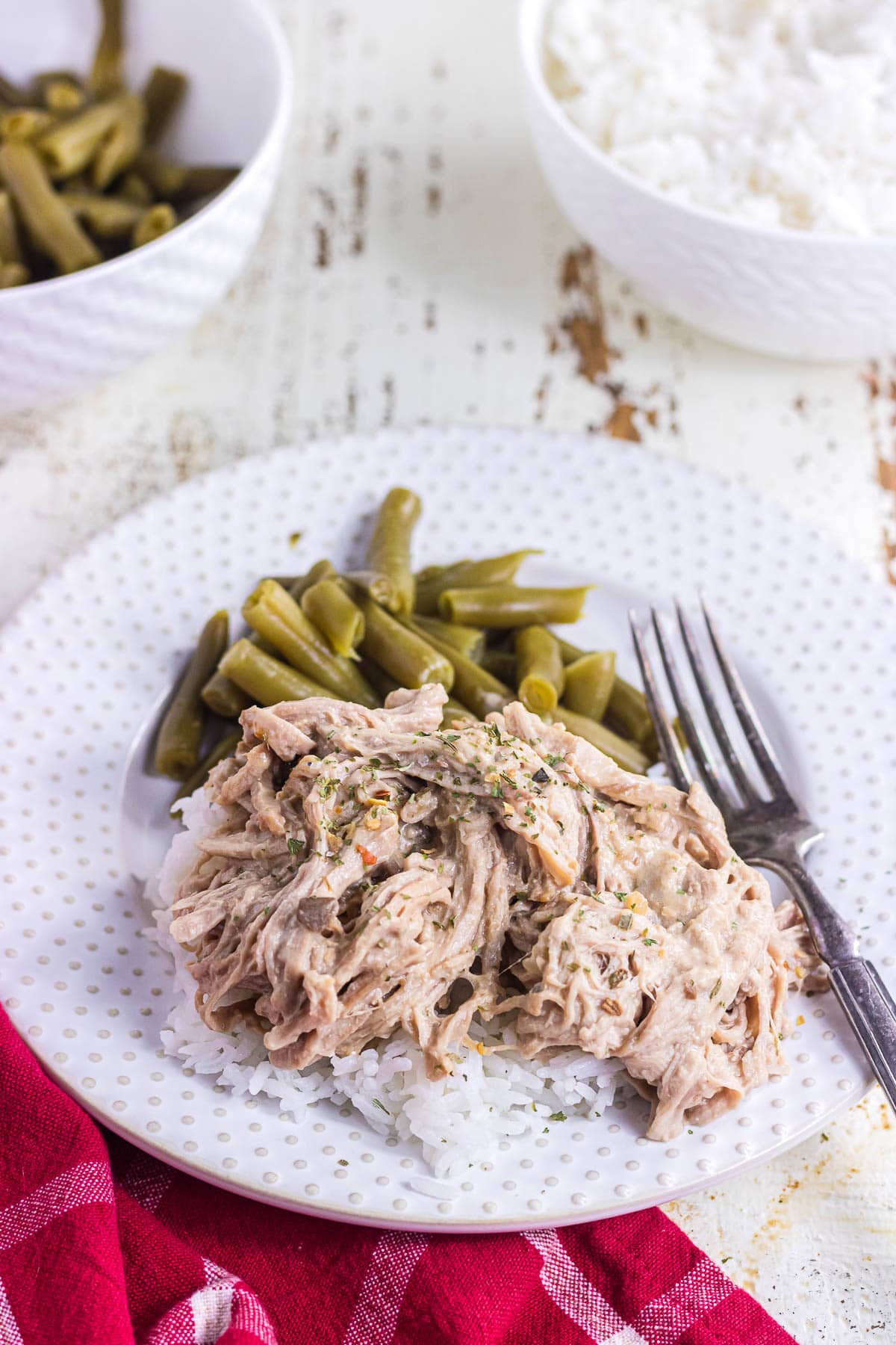 An angled view of creamy slow cooked pork tenderloin on a dinner plate.