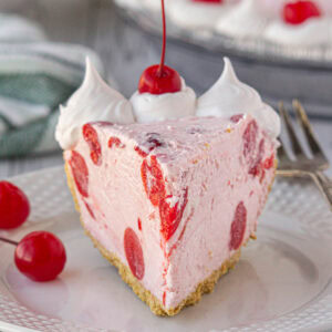 A slice of cherry icebox pie with whipped cream on top.