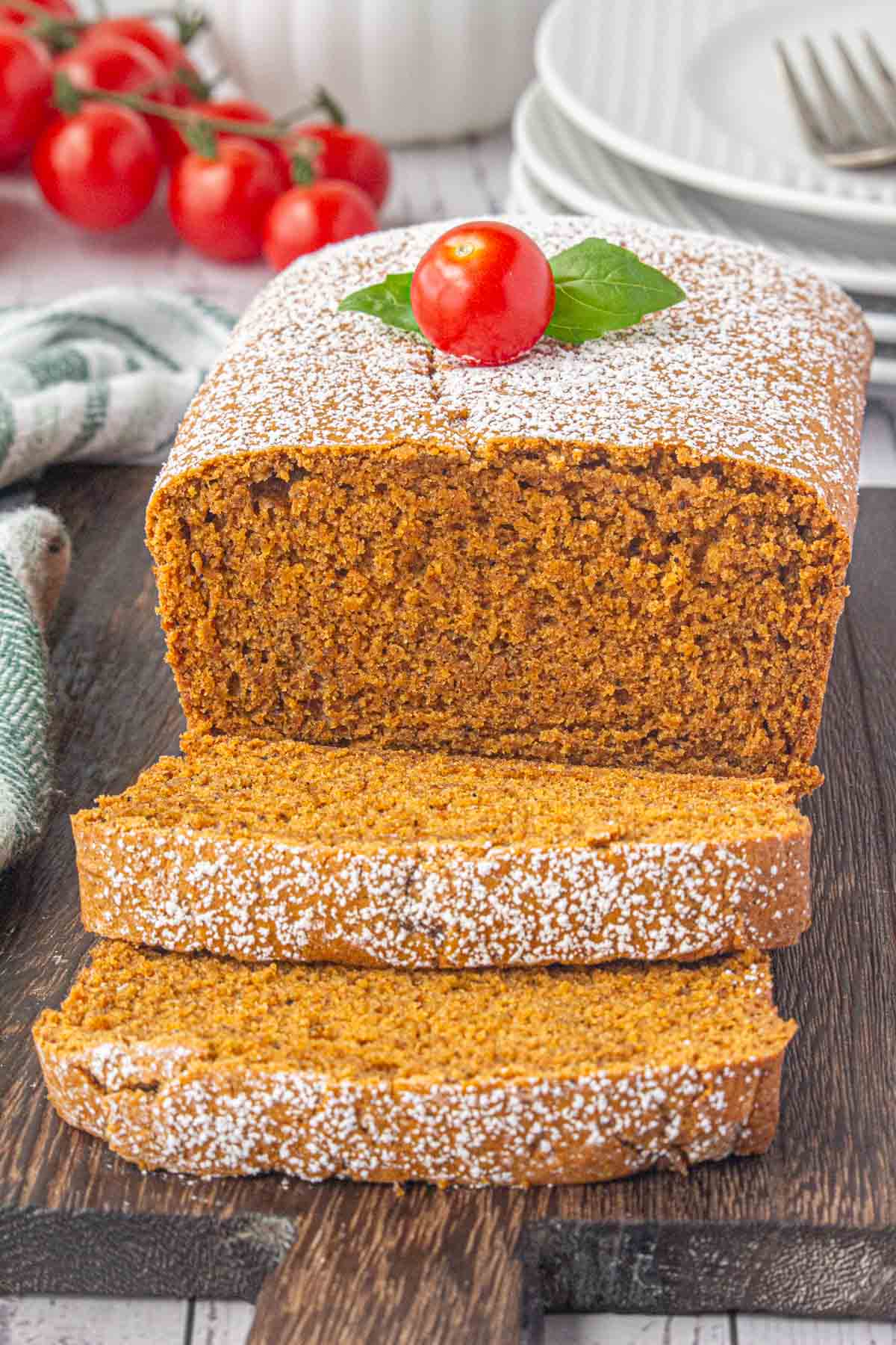 An angled view of sliced tomato cake on a serving board.