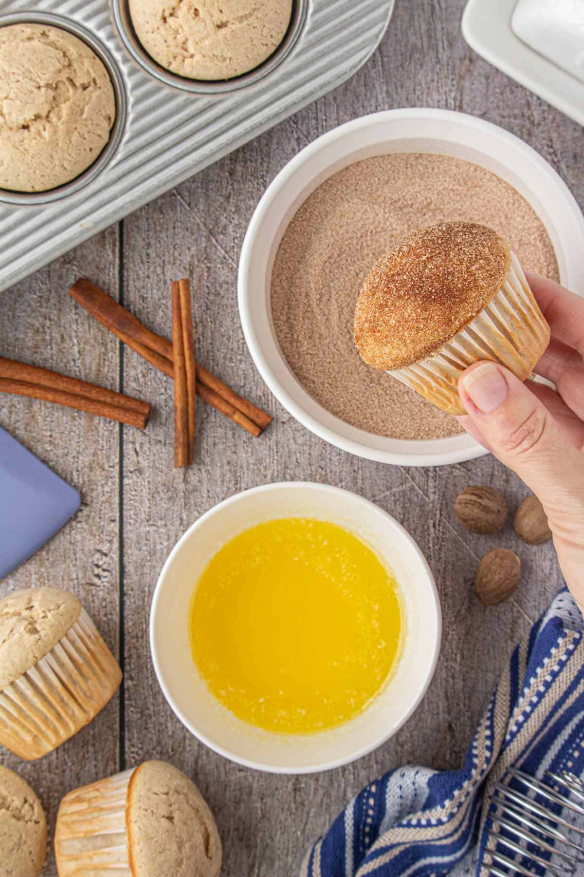 Dipping the French breakfast puffs in butter and cinnamon sugar.