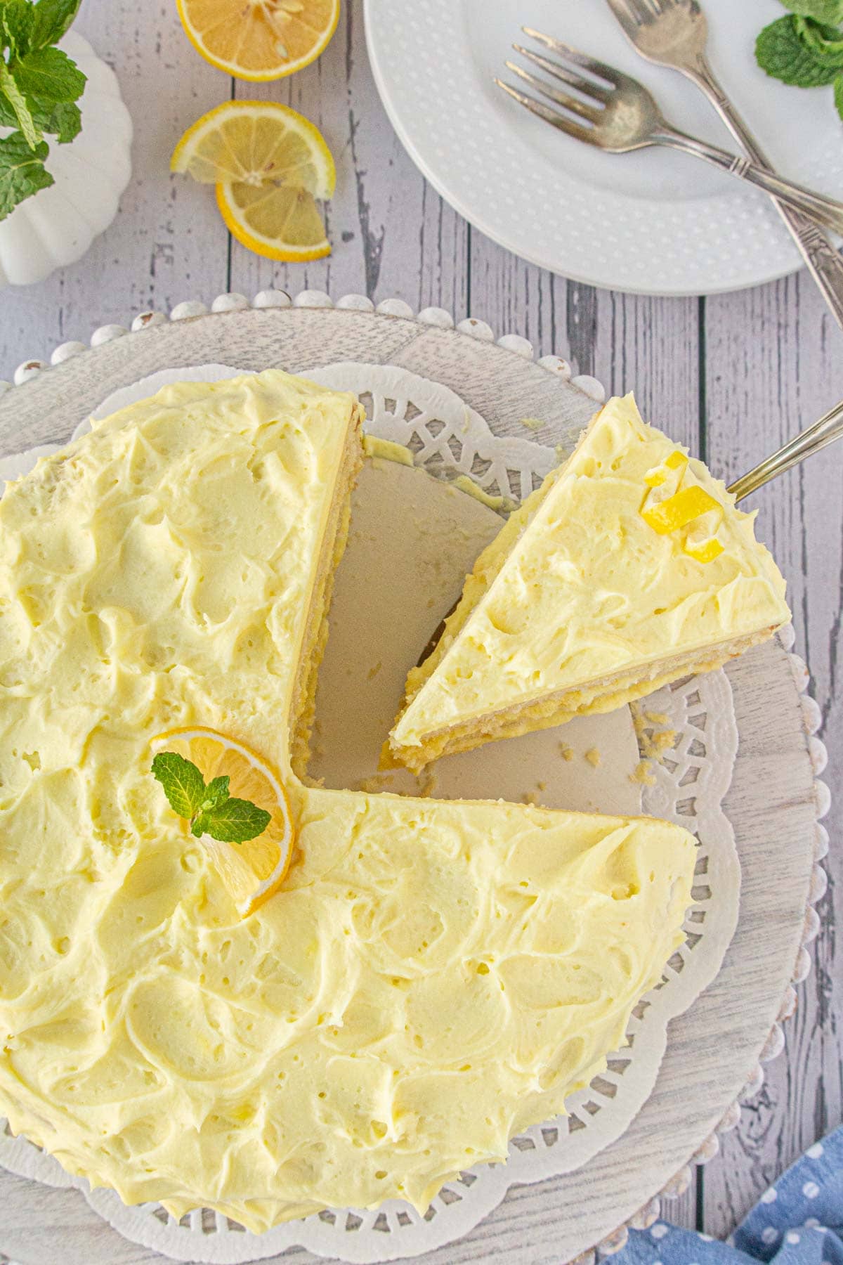 An overhead view of moist lemon cake. One slice is on a cake server.