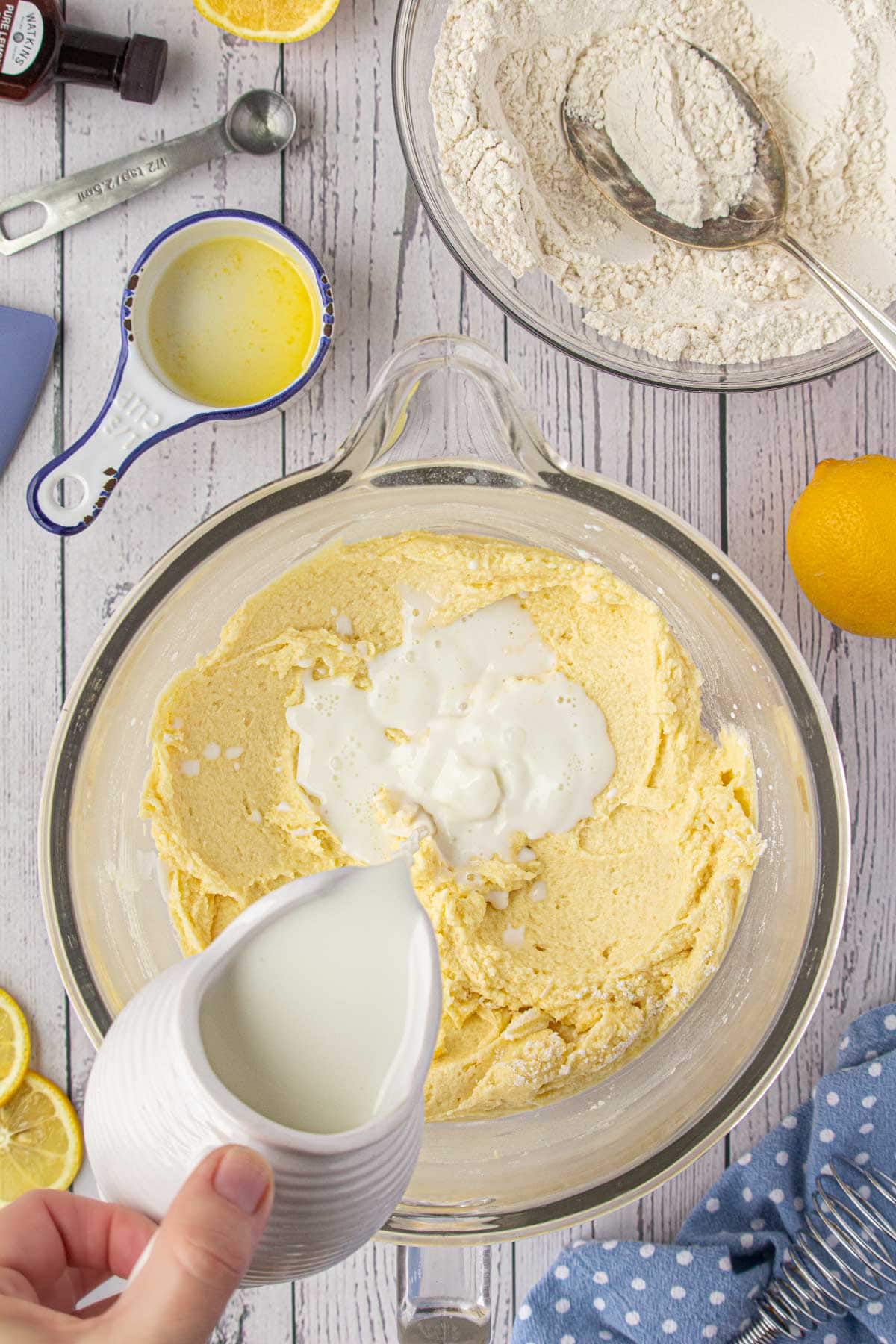 Pouring the milk into the batter and adding the flour.