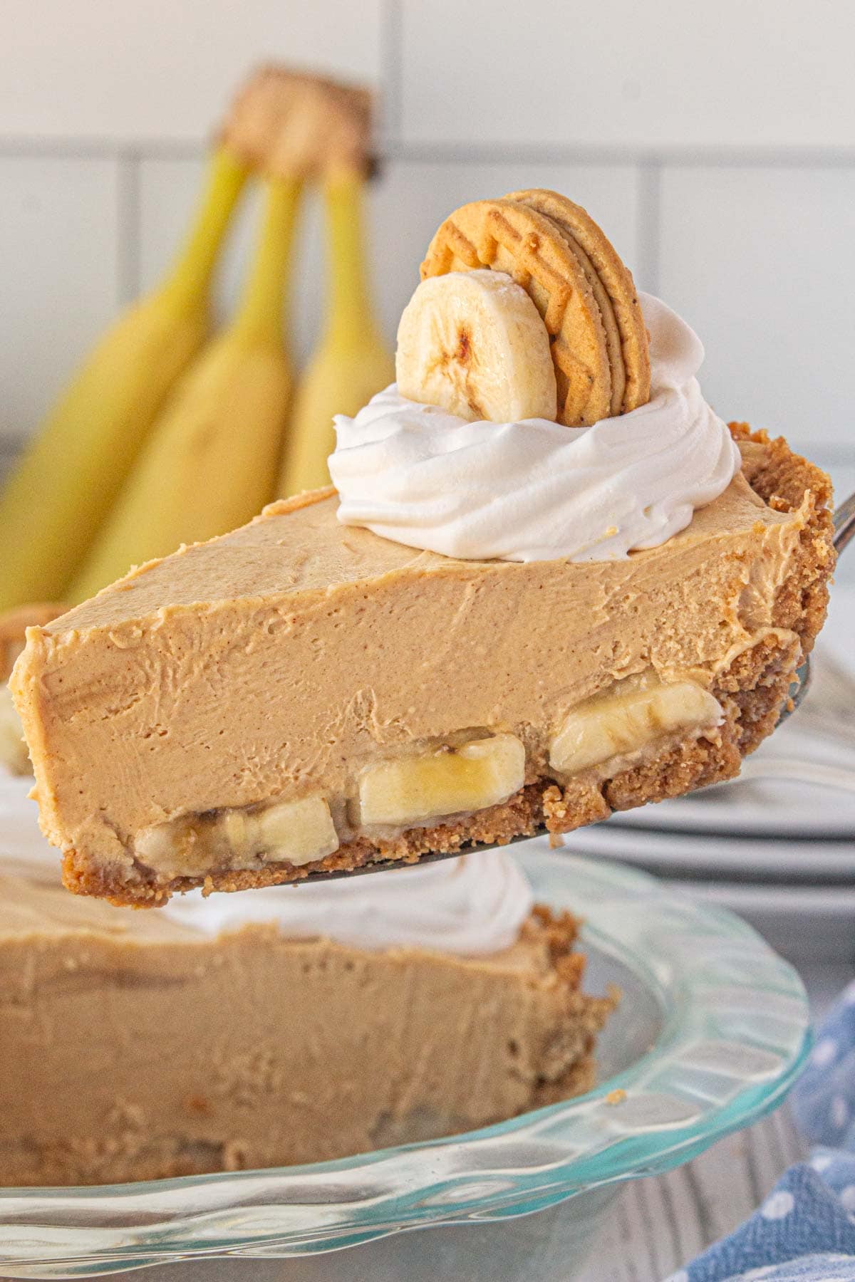 An up-close view of a slice of peanut butter banana icebox pie on a pie server.