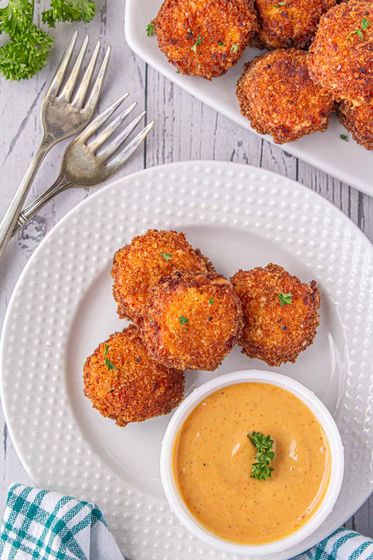 An overhead view of crispy fried pimento cheese balls on an appetizer plate with dipping sauce.