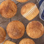 Overhead view of a batch of French breakfast puffs - fluffy muffins covered in cinnamon and sugar that taste like donuts! Title text overlay for Pinterest.