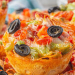 Closeup of pizza cups with title text overlay for Pinterest.